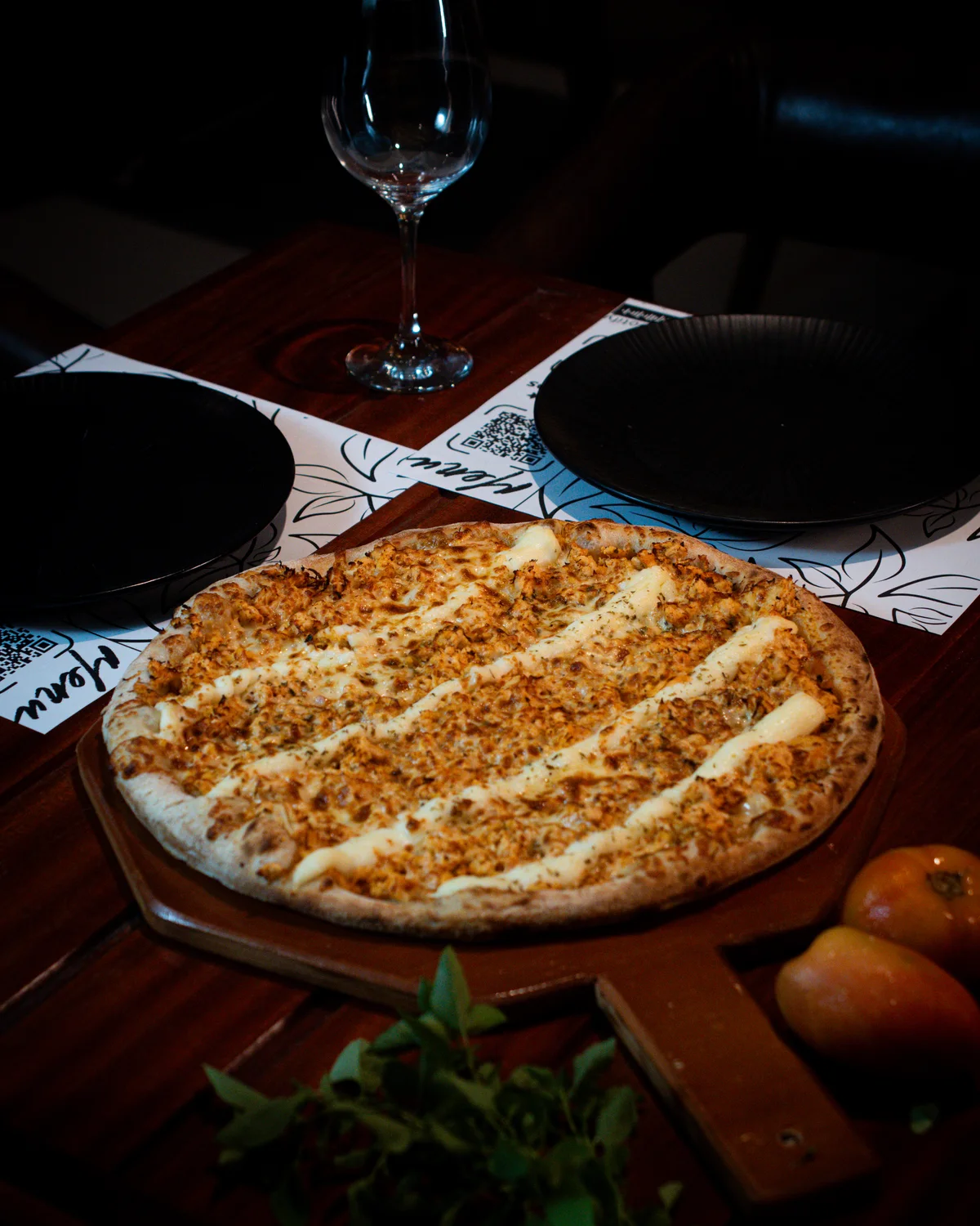 Mesa posta com pizza e taças de vinho